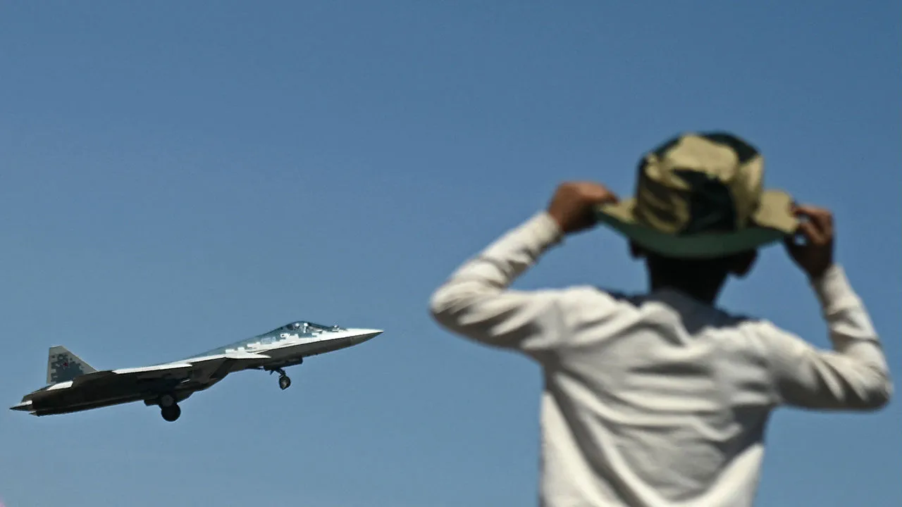 एउटा केटाले रुसी सुखोई सु–५७ पाँचौं पुस्ताको लडाकु विमान एरो इन्डिया २०२५ को दौरान उडान भर्दै गरेको हेर्छ फोटोः गेटी इमेजेस